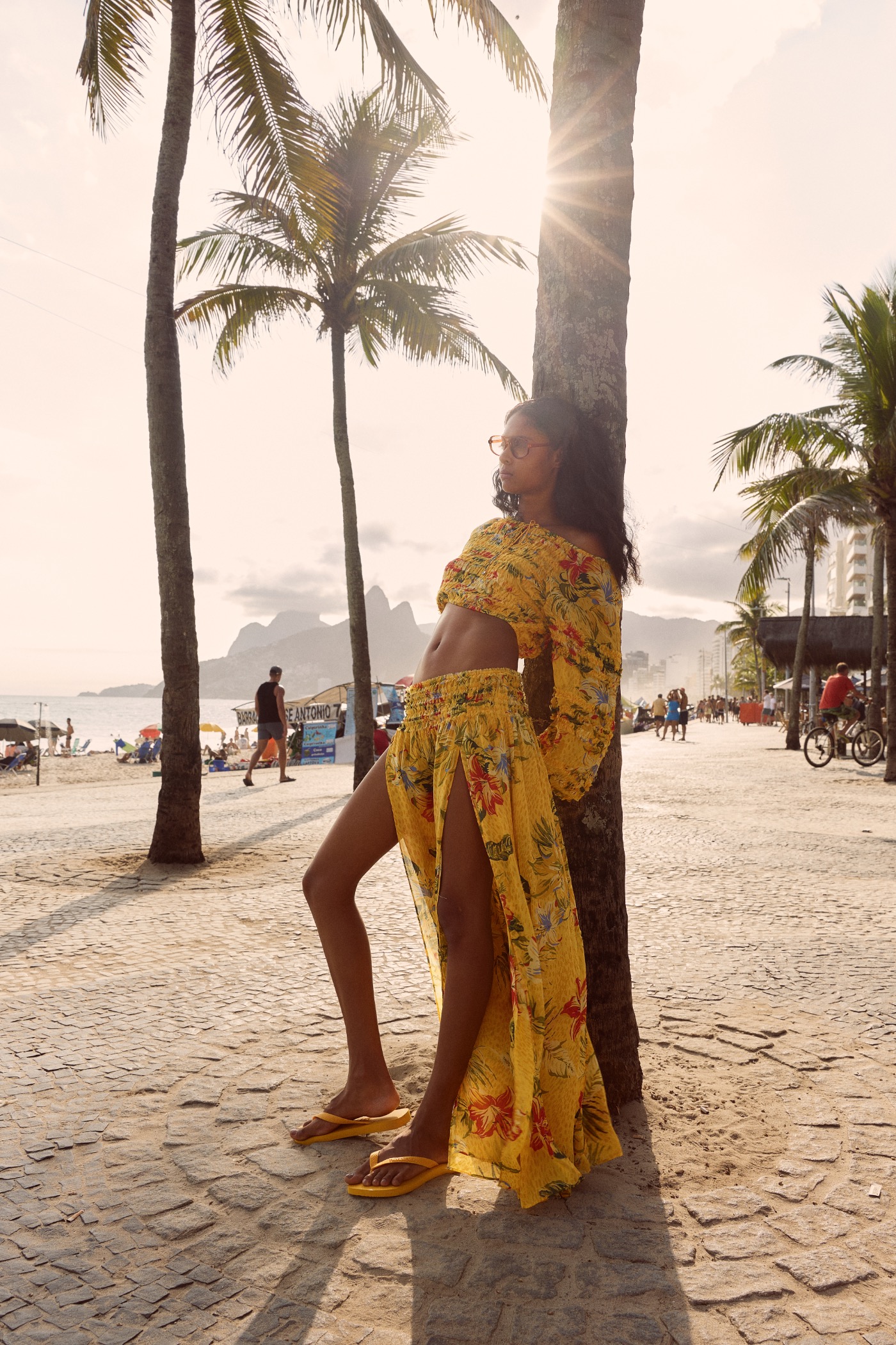 Magali Pascal ALEGRIA campaign, yellow floral look on the Ipanema boardwalk at sunset