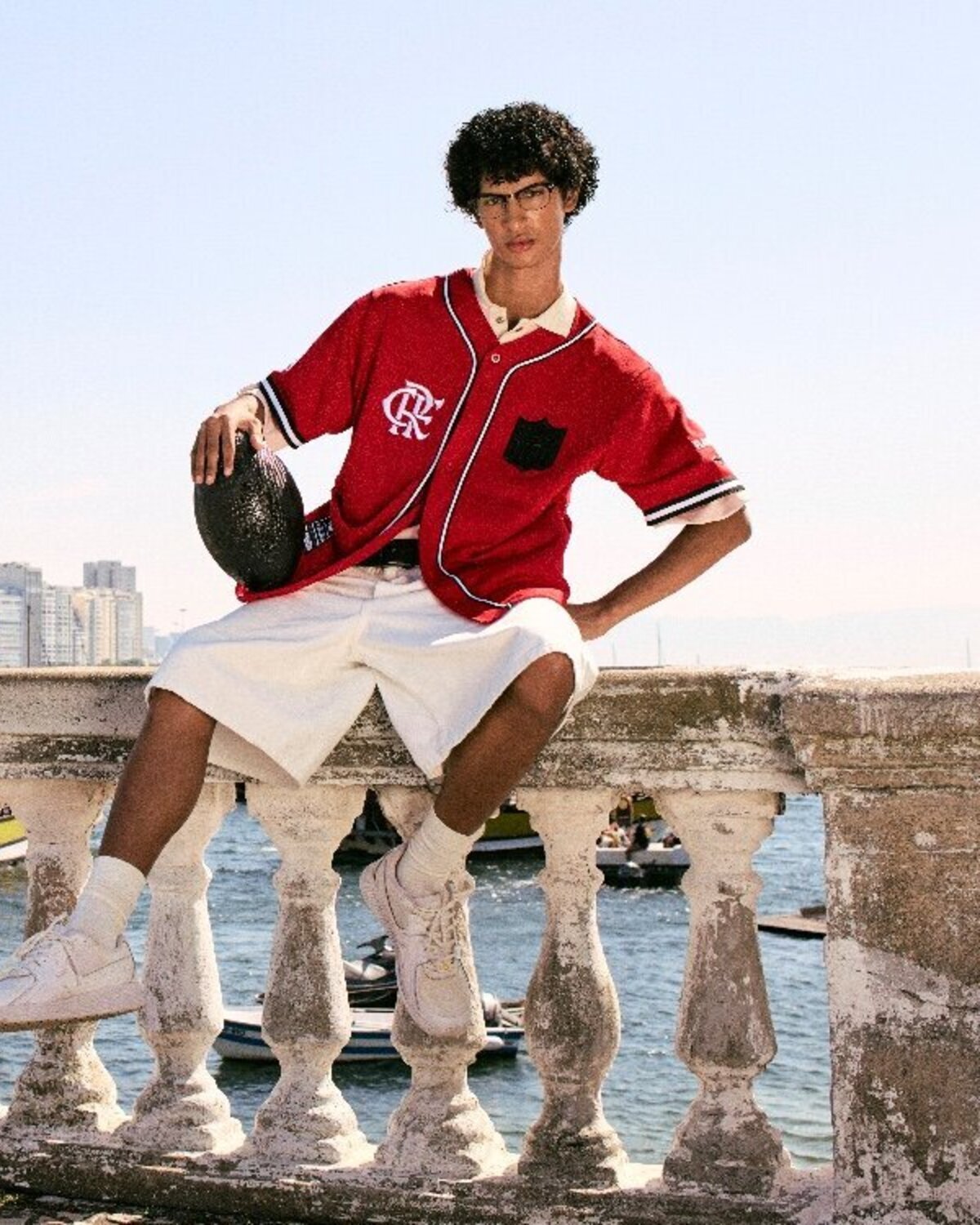 ProStandard NFL × Flamengo campaign, model in the red baseball jersey on a waterfront balustrade